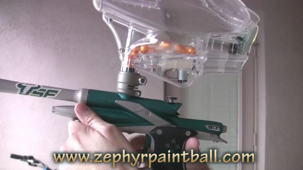 A paintball hopper mounted on top of a marker feeding into the breech
